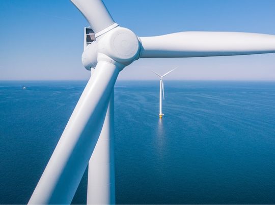 Birds-eye view of wind turbine in ocean.