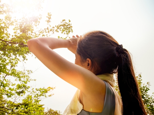 Person looking toward the sky on a hot day.
