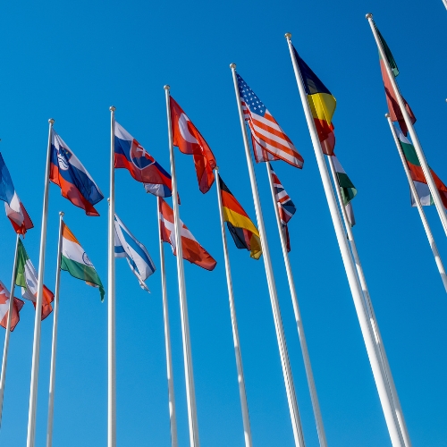 Tall national flags against a blue sky