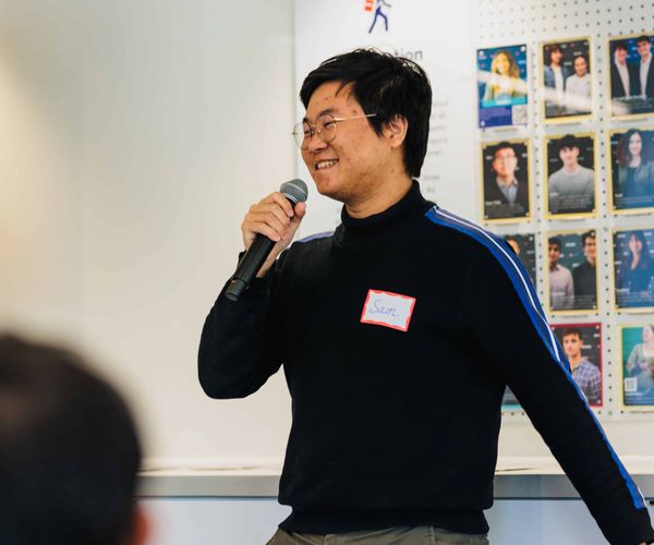 Man speaks into a microphone while smiling