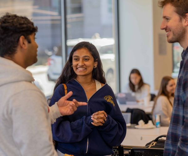 Woman smiling in conversation with other students