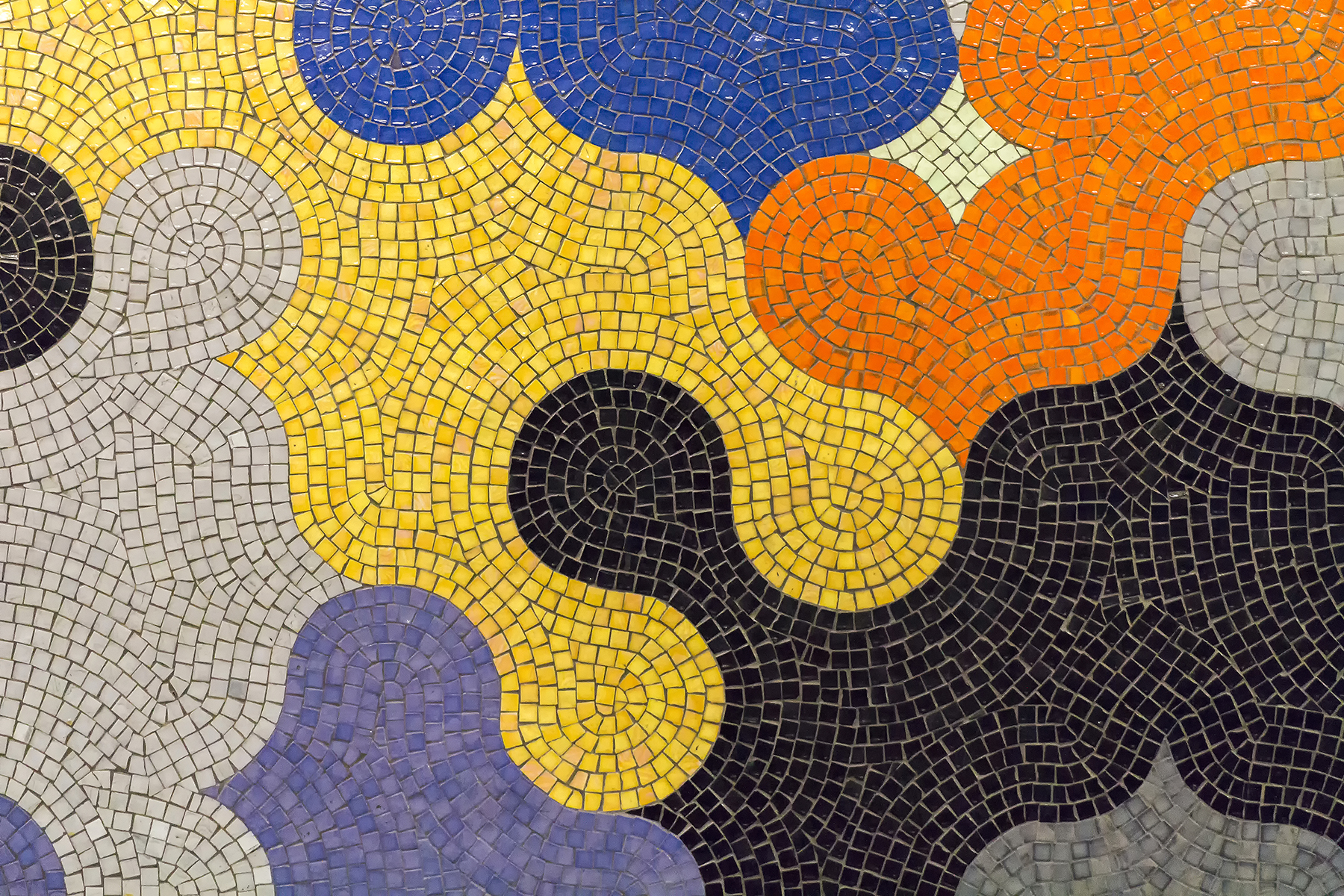 A mosaic of yellow, black, grey, orange, blue, and purple tiles
