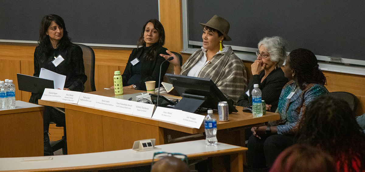 A group of panelists discuss at a long table.