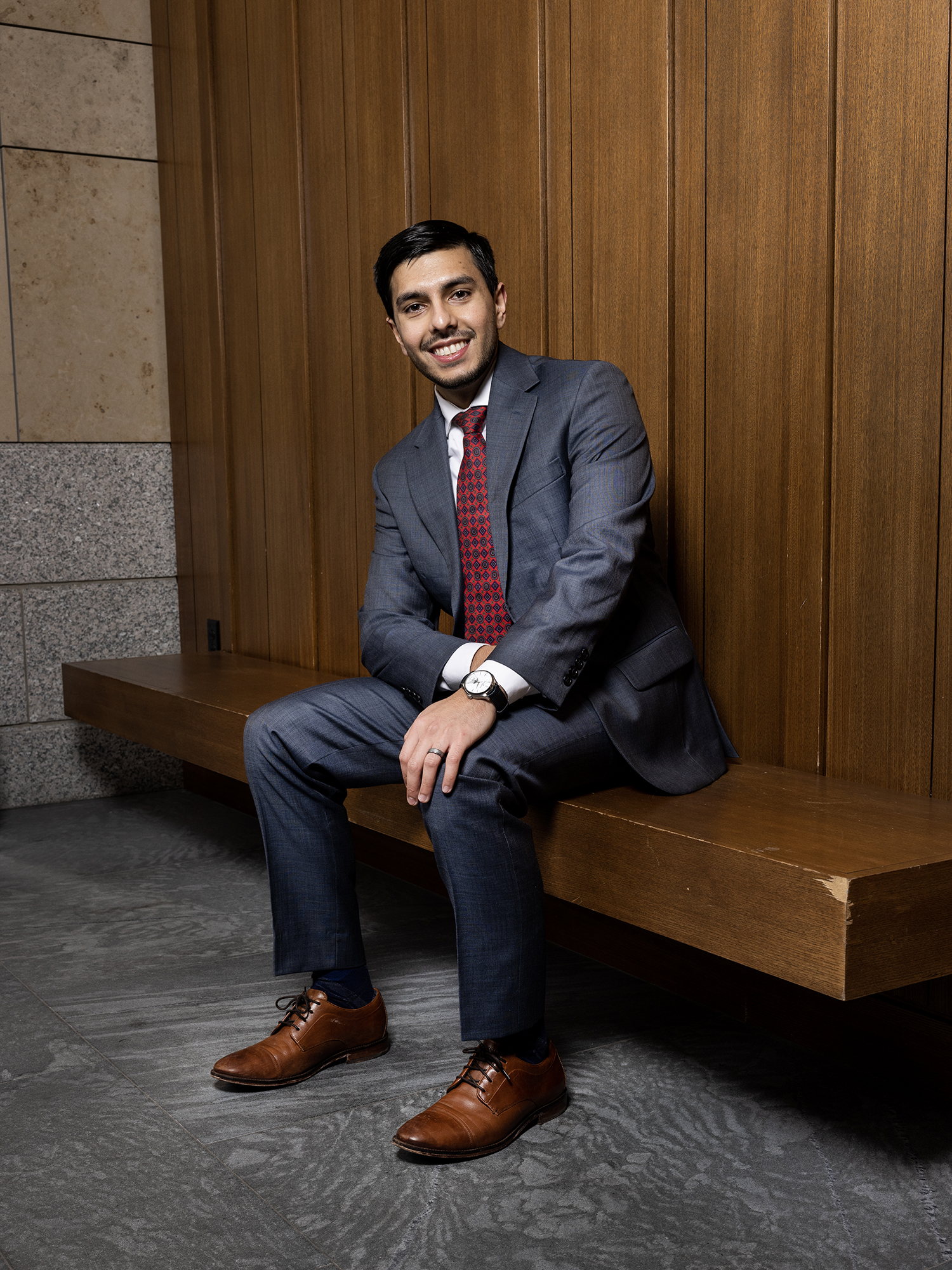 Ibrahim Ahmed Ijaz, Class of 2023, sits in the atrium of the Redstone building