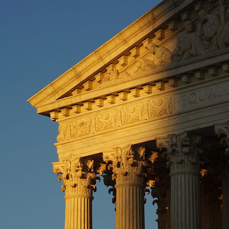 The facade of the US Supreme Court building half obscured by shadow