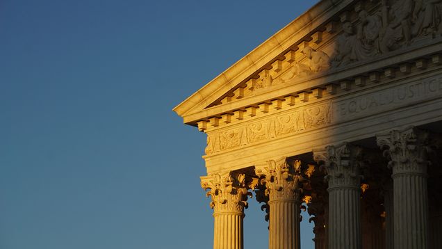 The facade of the US Supreme Court building half obscured by shadow