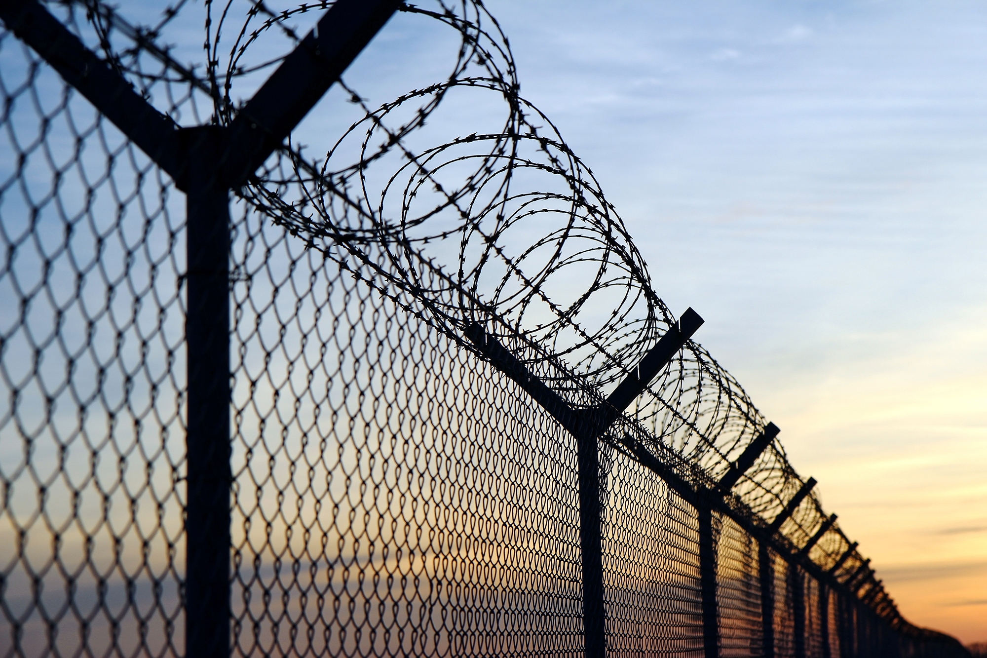 A razor wire fence at dusk