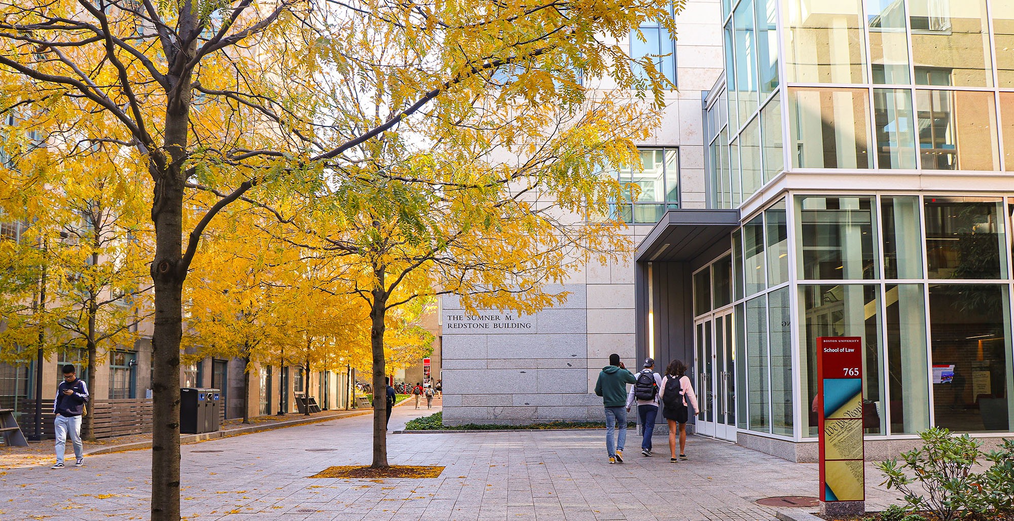 Students walk into the law complex on a fall day.