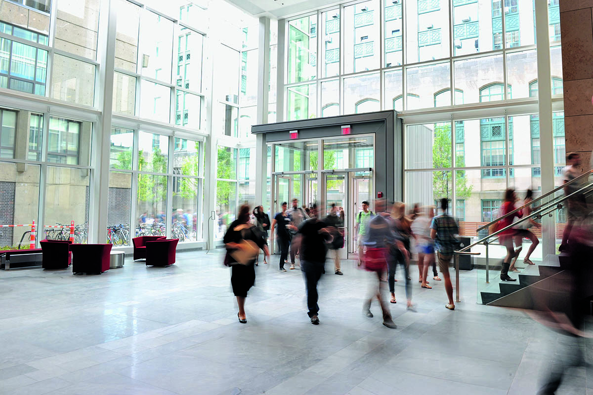 Students walk around in the atrium of the law tower.