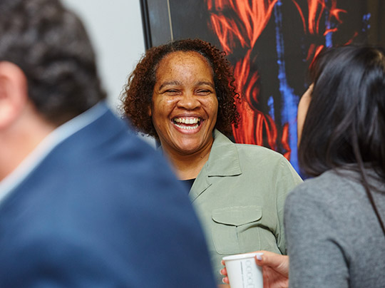 Get Started at BU MET. Image shows an excited student interacting at an event with other students at the BU.