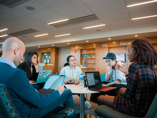 A diverse group of students sitting around a round table.