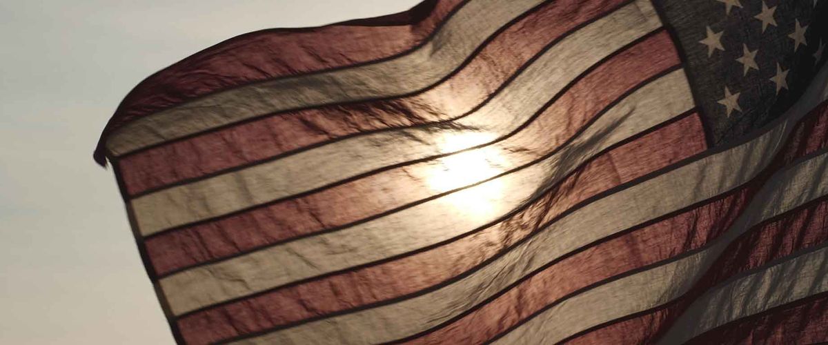 American USA flag waving in sunset outdoor background for honoring USA military