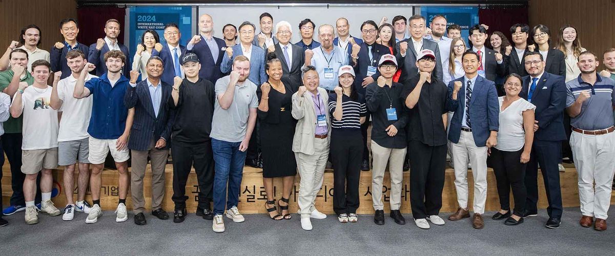 A large group of participants posing together at the 2024 White Hat Conference
