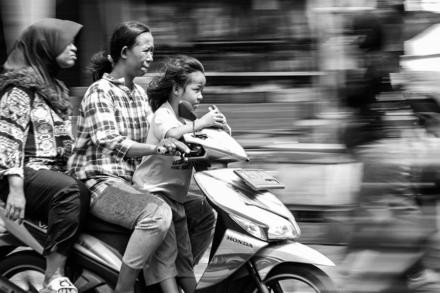 A motorbike with three riders in Indonesia