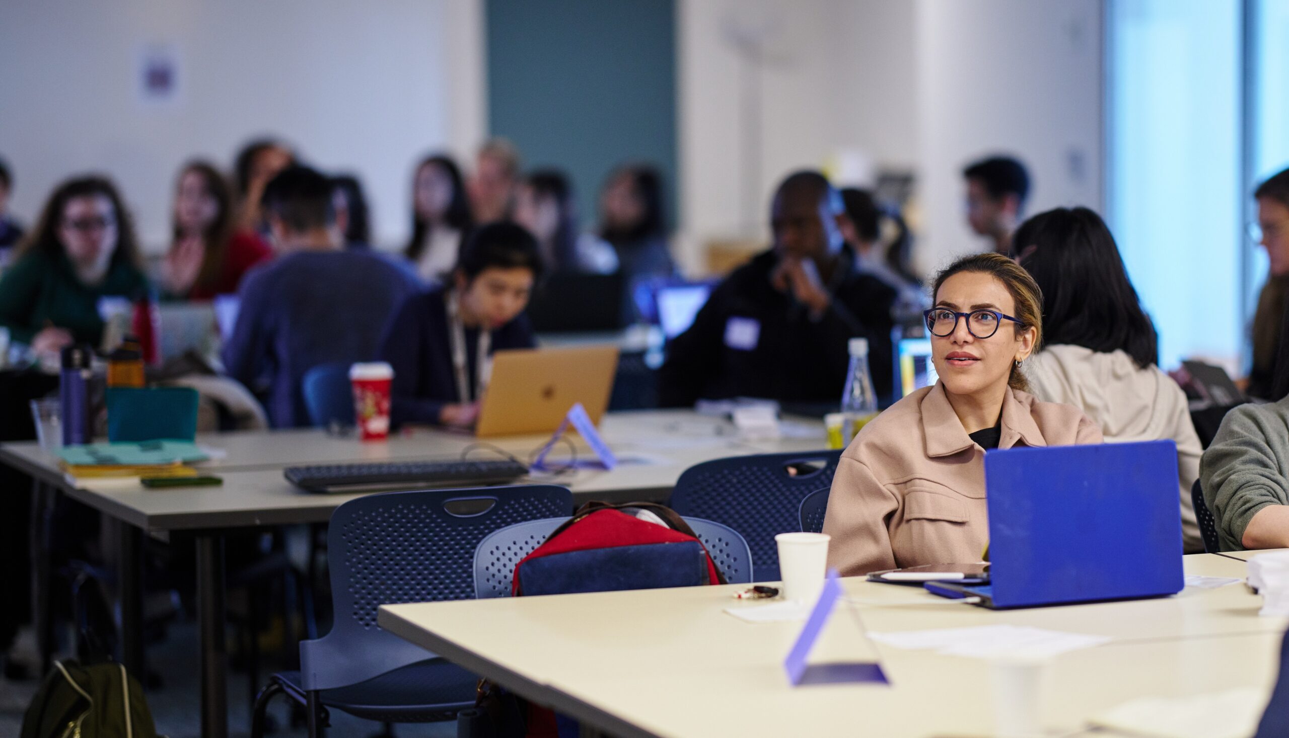 Woman attentively watches a workshop presentation.