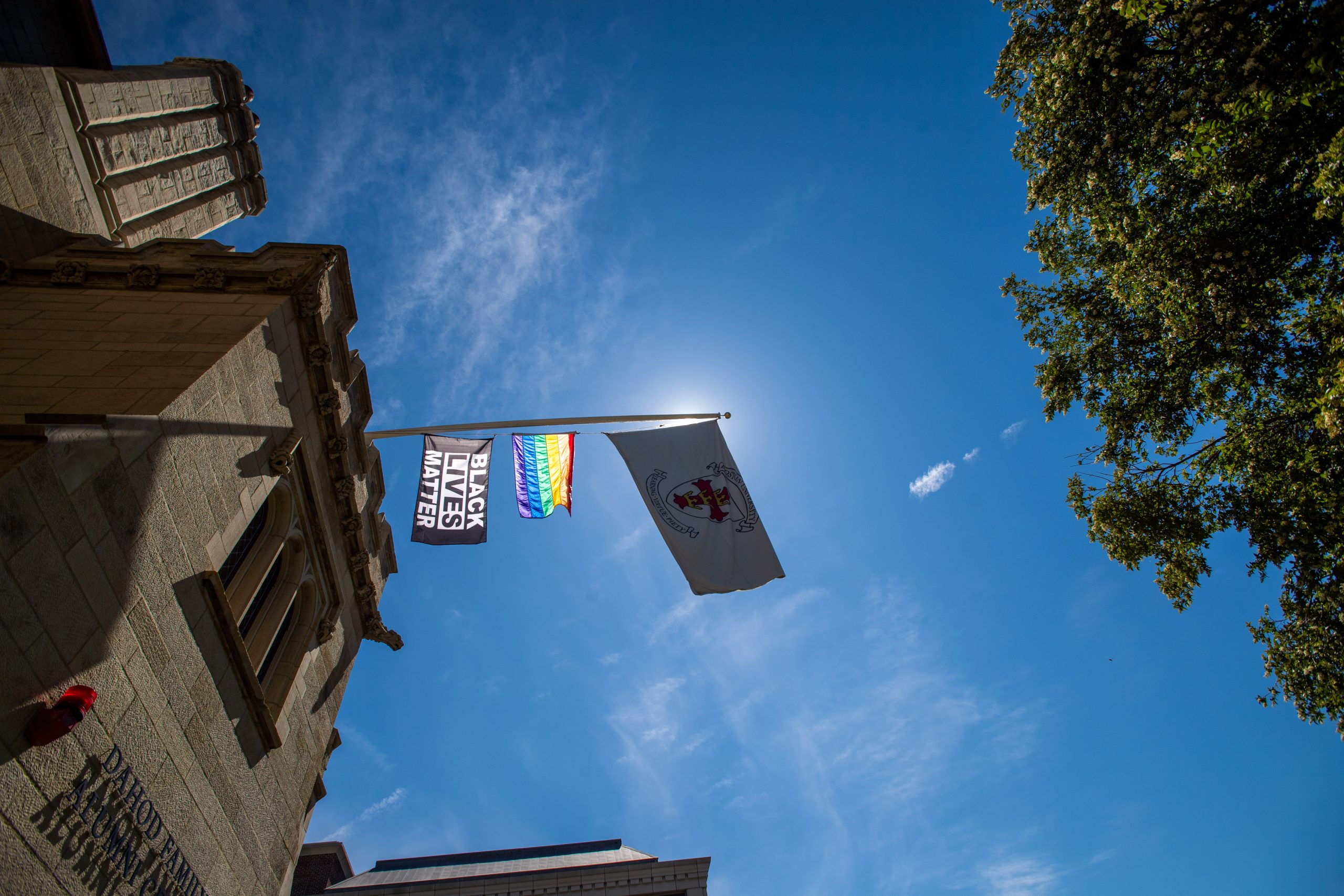 A Black Lives Matter and Pride flag flies above the Dahod Family Alumni Center.