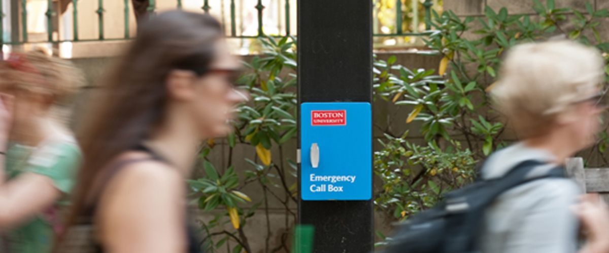 Students walking by an emergency call box at Boston University