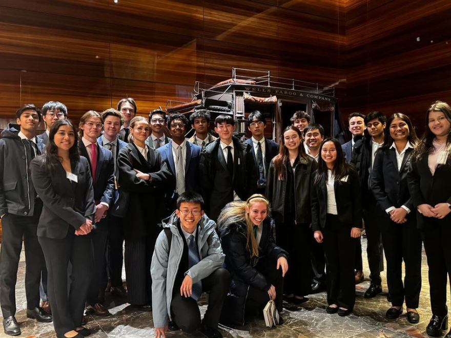 Finance club dressed in business professional poses at a company visit.