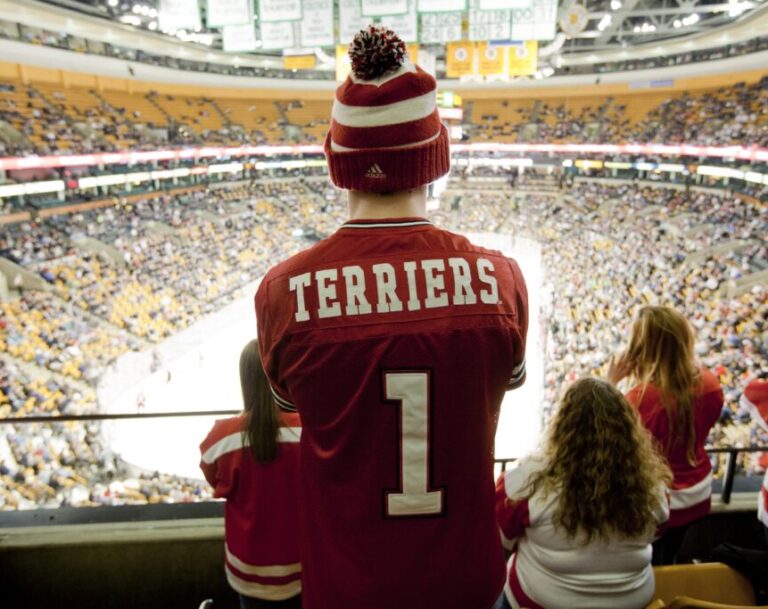 A photo of a male student watching a BU Terriers hockey game.