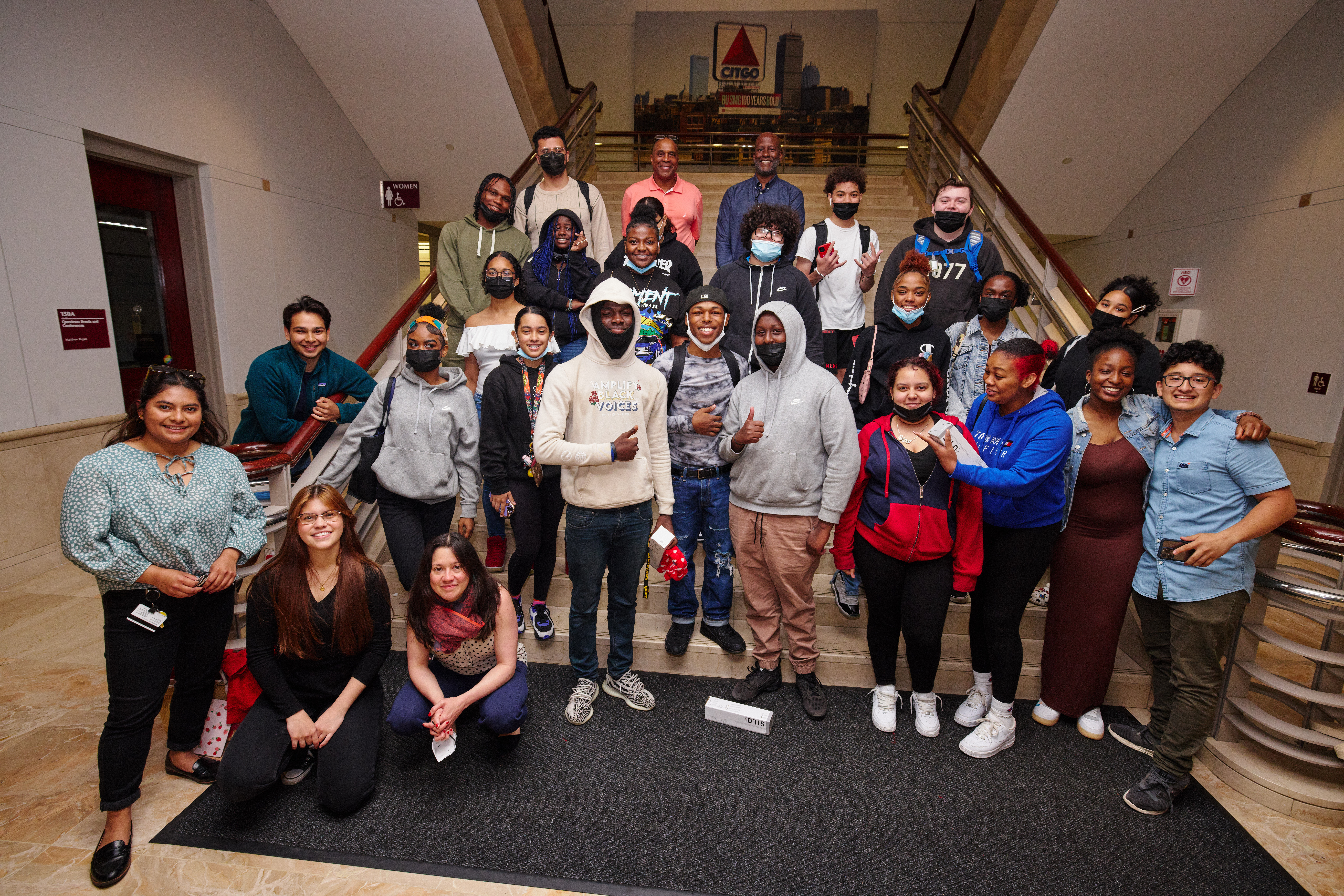 Group of students posing for a photo in front of a large staircase