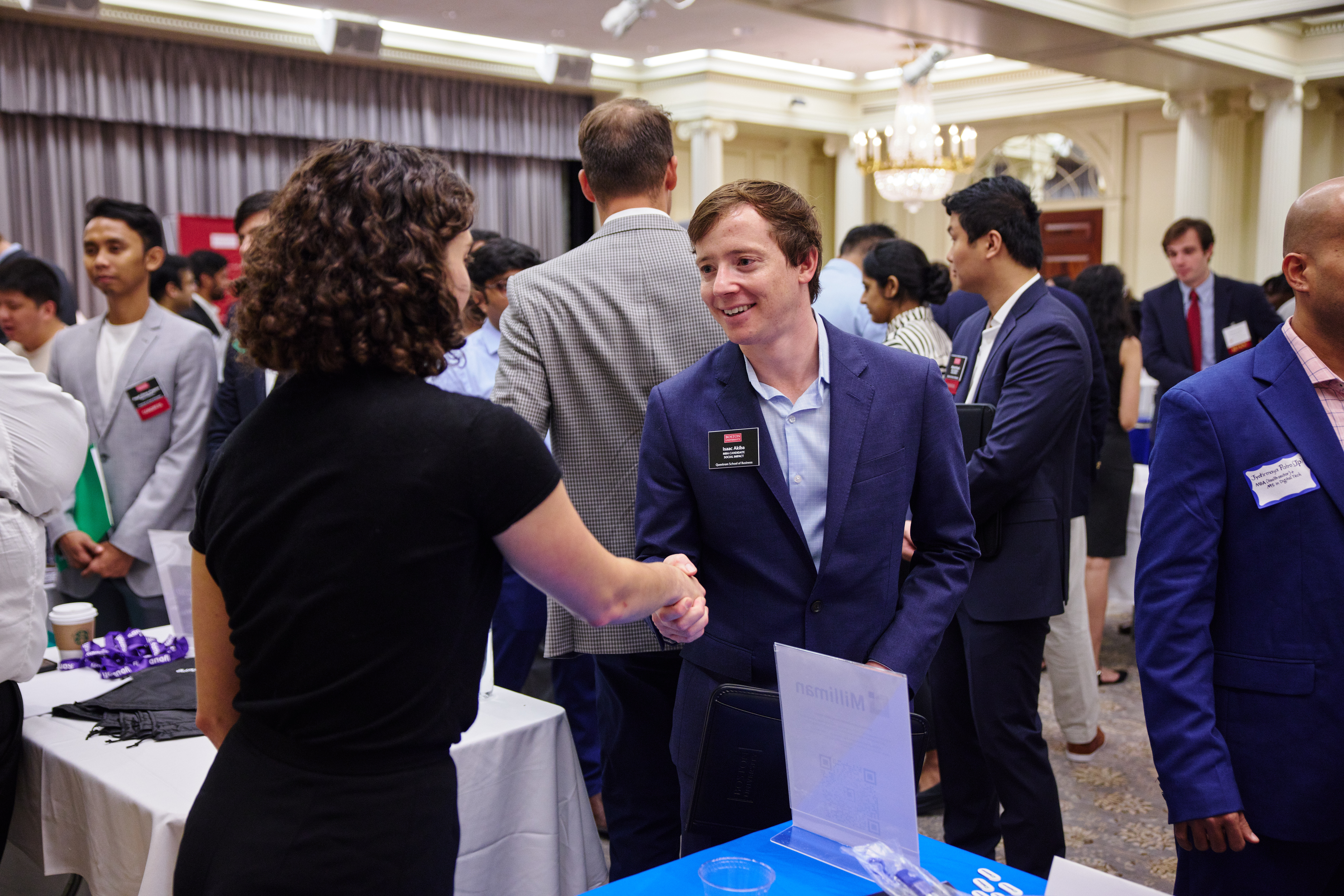 An MBA student shakes the hand of a potential employer