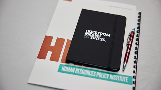 BU Questrom notebook and pen on top of Human Resources Policy Institute handbook