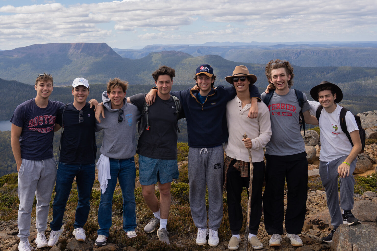 A group of men study abroad students pose at the top of a mountain in Australia