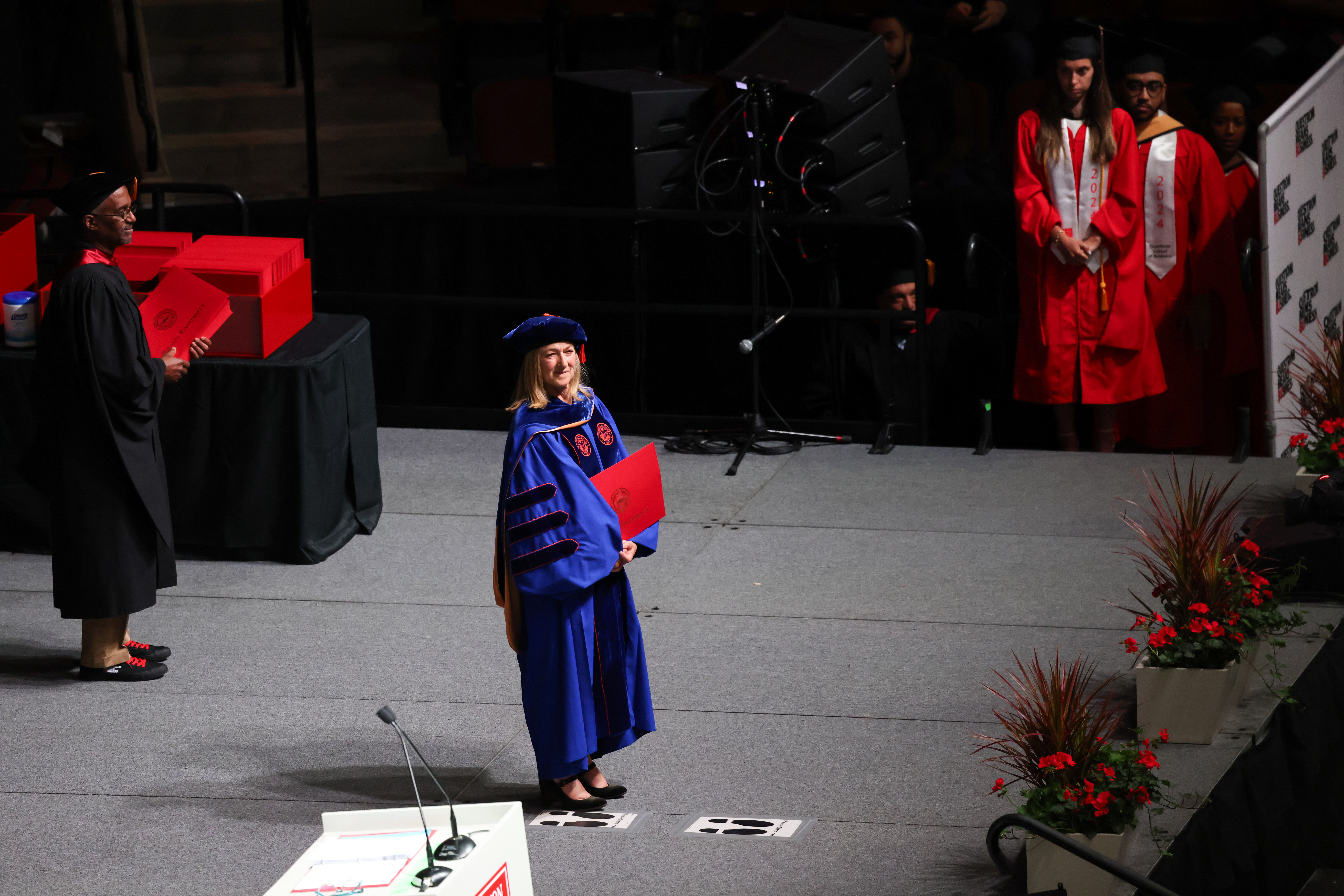 Dean Fournier standing on stage at commencement
