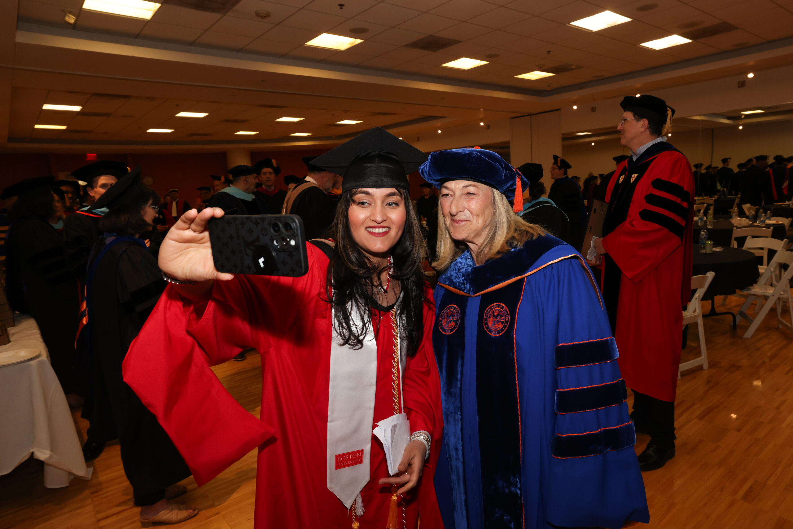 Dean Fournier posing for a selfie with a student at graduation