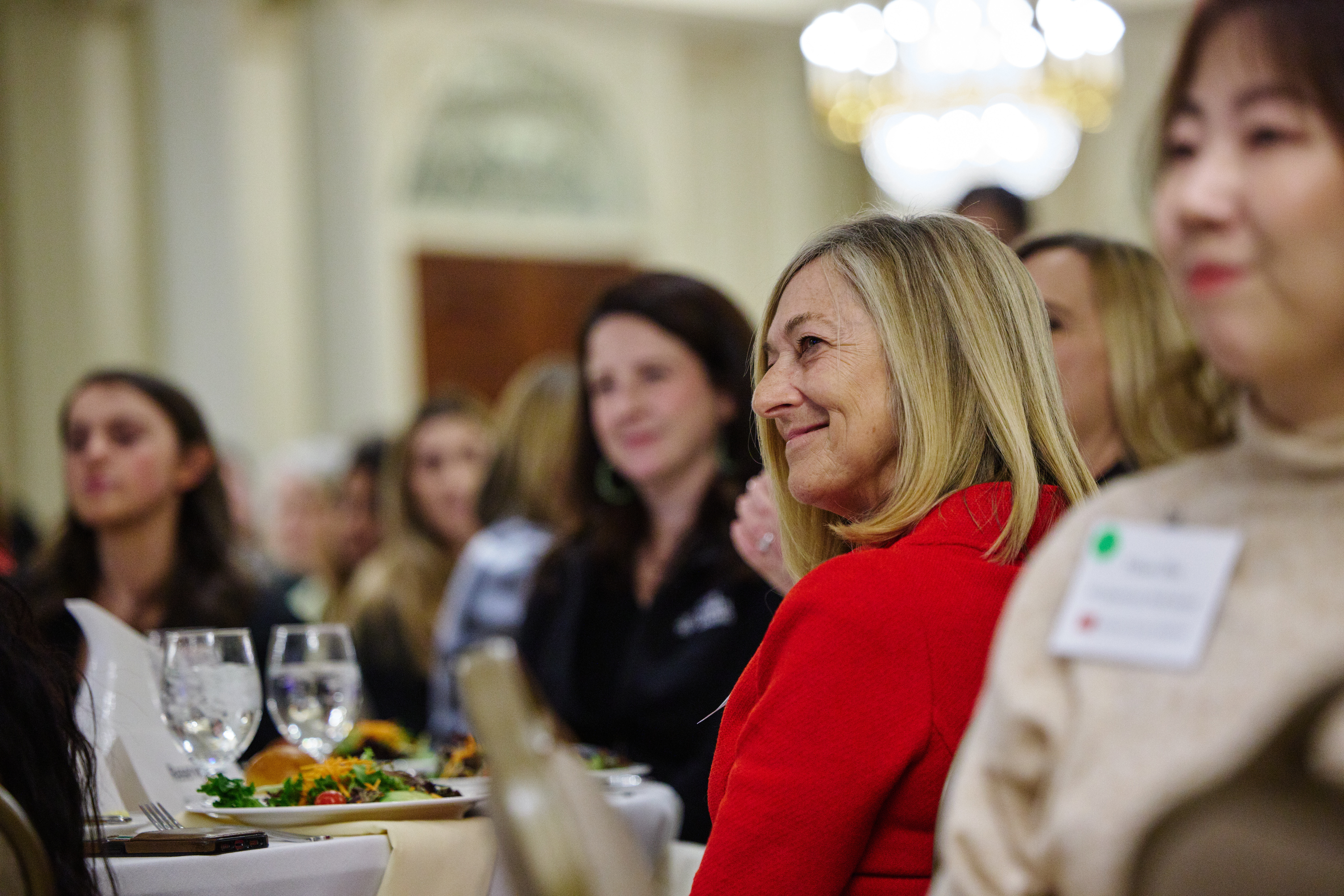 Dean Fournier seated at a table at an event listening to someone speak