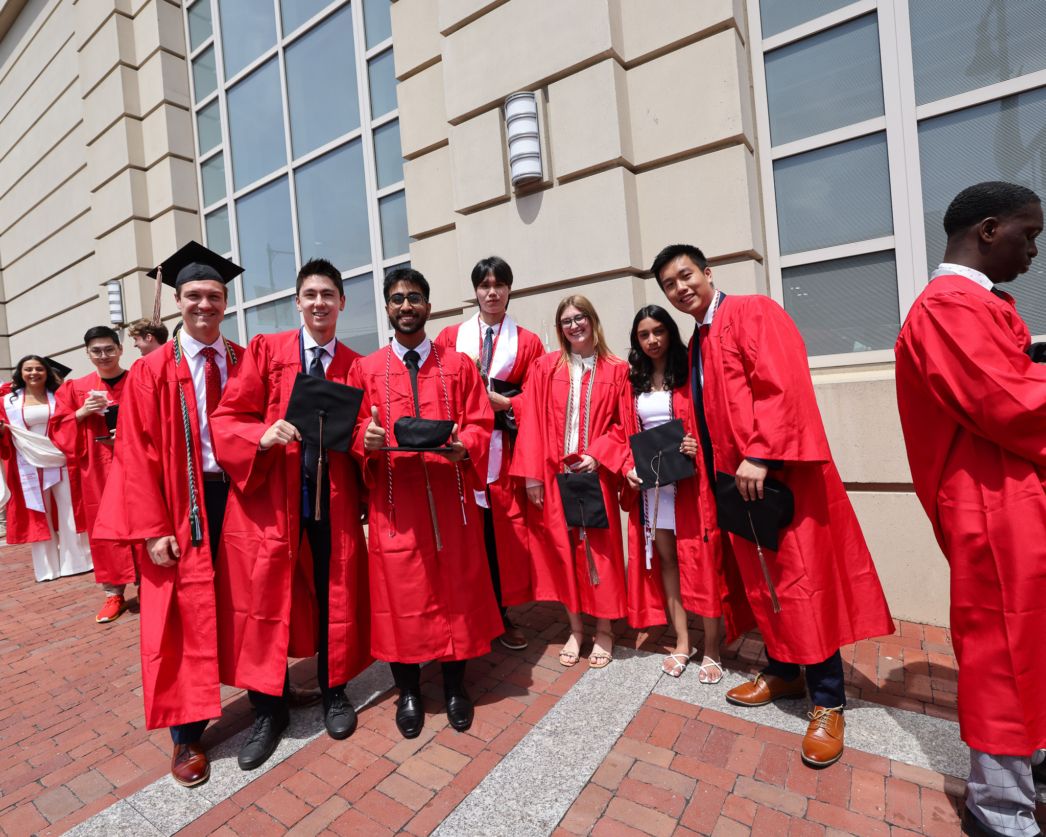 group of grads in caps and gowns pose outside