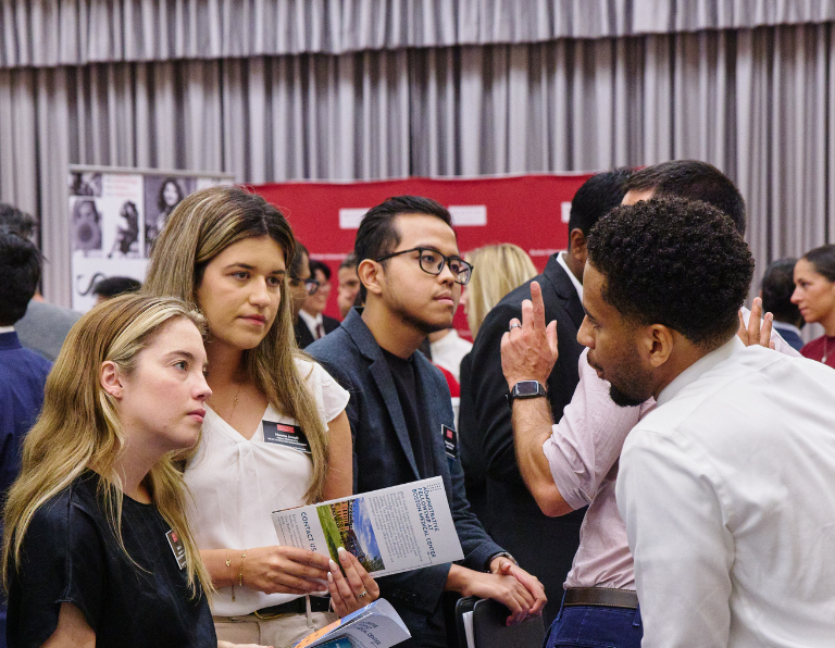 Students engaging with employers at a busy networking event