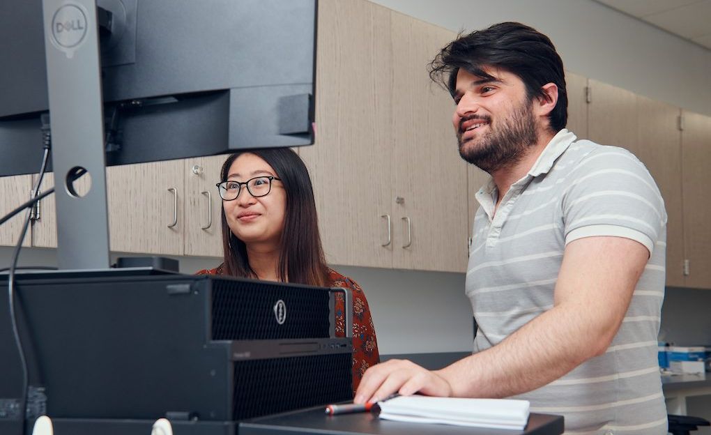 Two researchers looking at computer screen