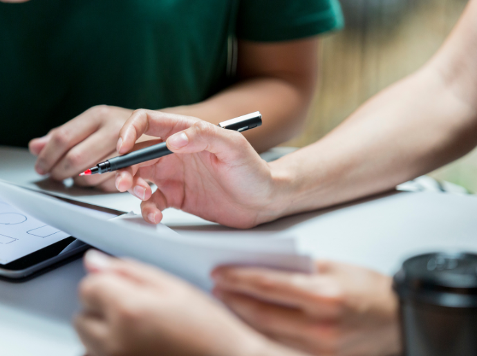 A group of people review papers on a table