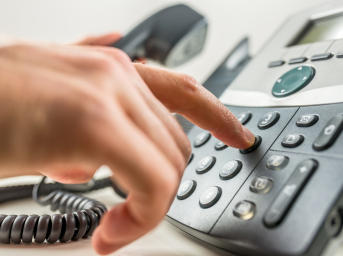 A close up photo of a person dialing a phone