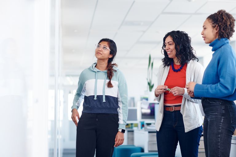 Three researchers looking at white board