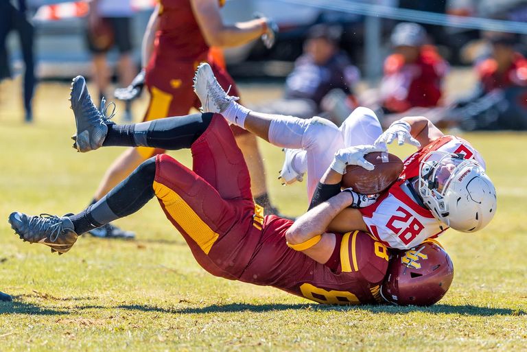 Two football players tackling each other on the field