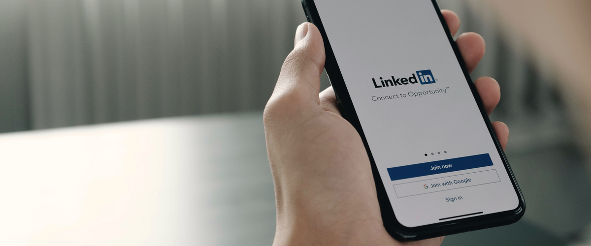 Person holding iPhone logging into Linkedin