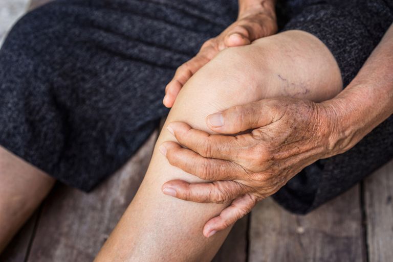 Holding knee in pain