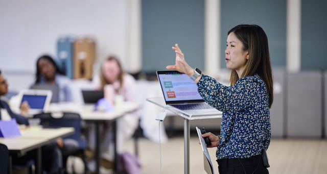 Woman speaking to a group, mid gesture