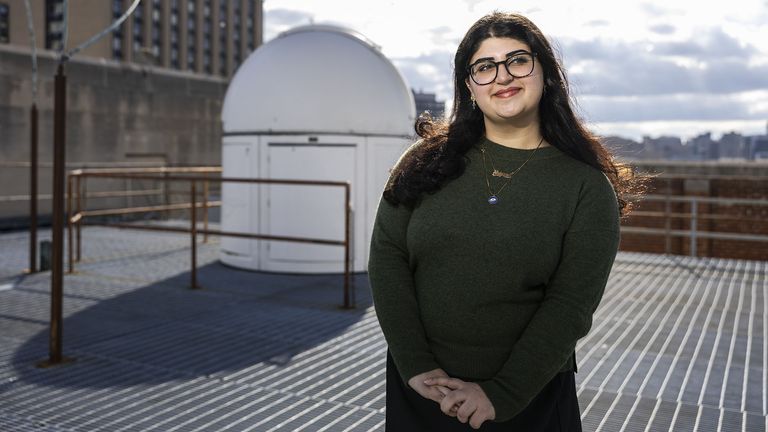 Astrophysics student Ariyana Bonab on BU roof with telescope