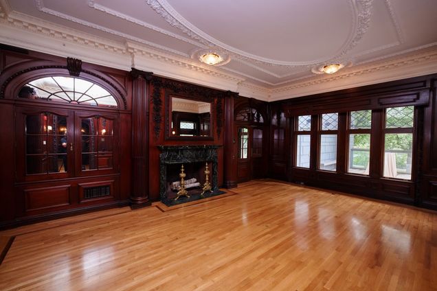 Empty room view of the Dining Room with hard woods floors and darker wood paneling and 4 windows.