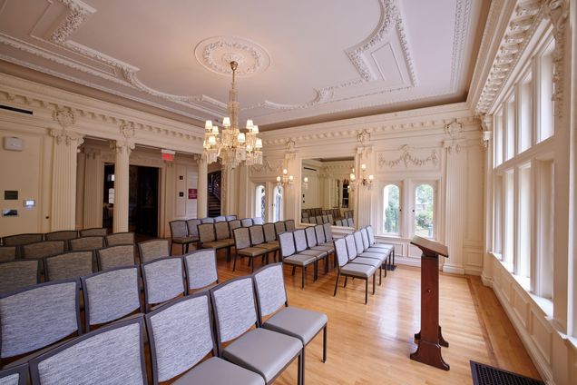 View from an angle of Music Room setup for a lecture with grey chairs in rows.