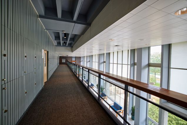 Long view of 3rd floor hall with bannister overlooking lounge below.