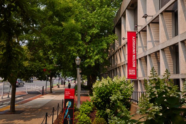 Exterior front of GSU with trees and shrubs, with red banner that says Boston University George Sherman Union.