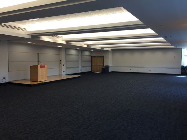 Empty room view of Colloquium Room, with podium with BU logo on it.
