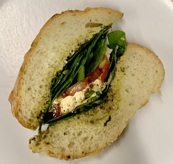 Do demonstrate the final result of caprese sandwich after ingredients are assembled.