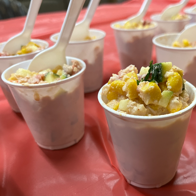 Mixed elote salad in individual cups .