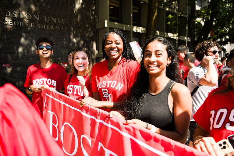 Students smiling holding BU banner