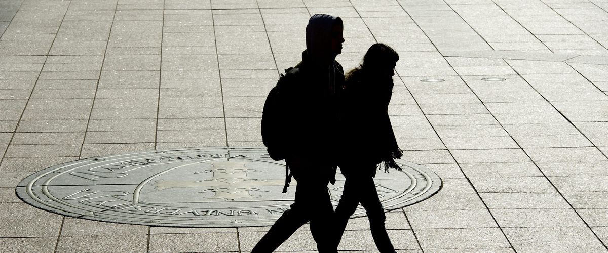 Two students walking outside on campus in shadow